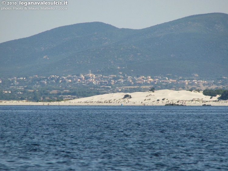 Porto Pino - Dune - 2009, agosto. Sullo sfondo, apparentemente vicino ma a 6,2 Km di distanza in linea d'aria, il paese di S.Anna Arresi