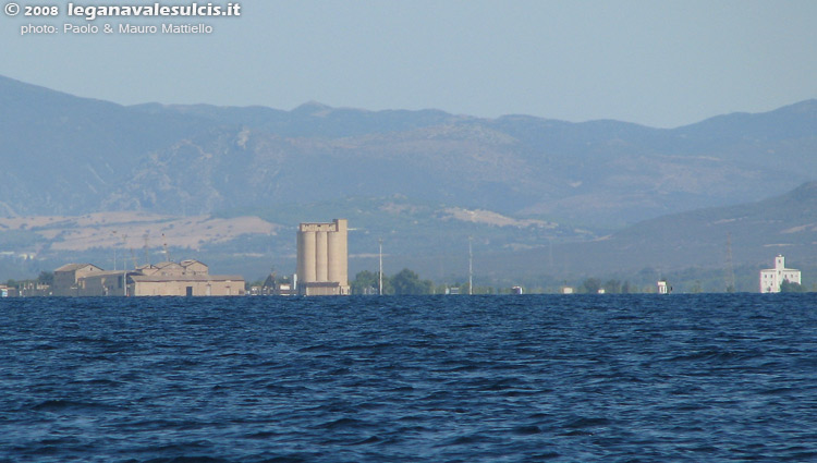 Porto di S.Antioco dal mare. In evidenza il grande silo a sinistra e il faro a destra